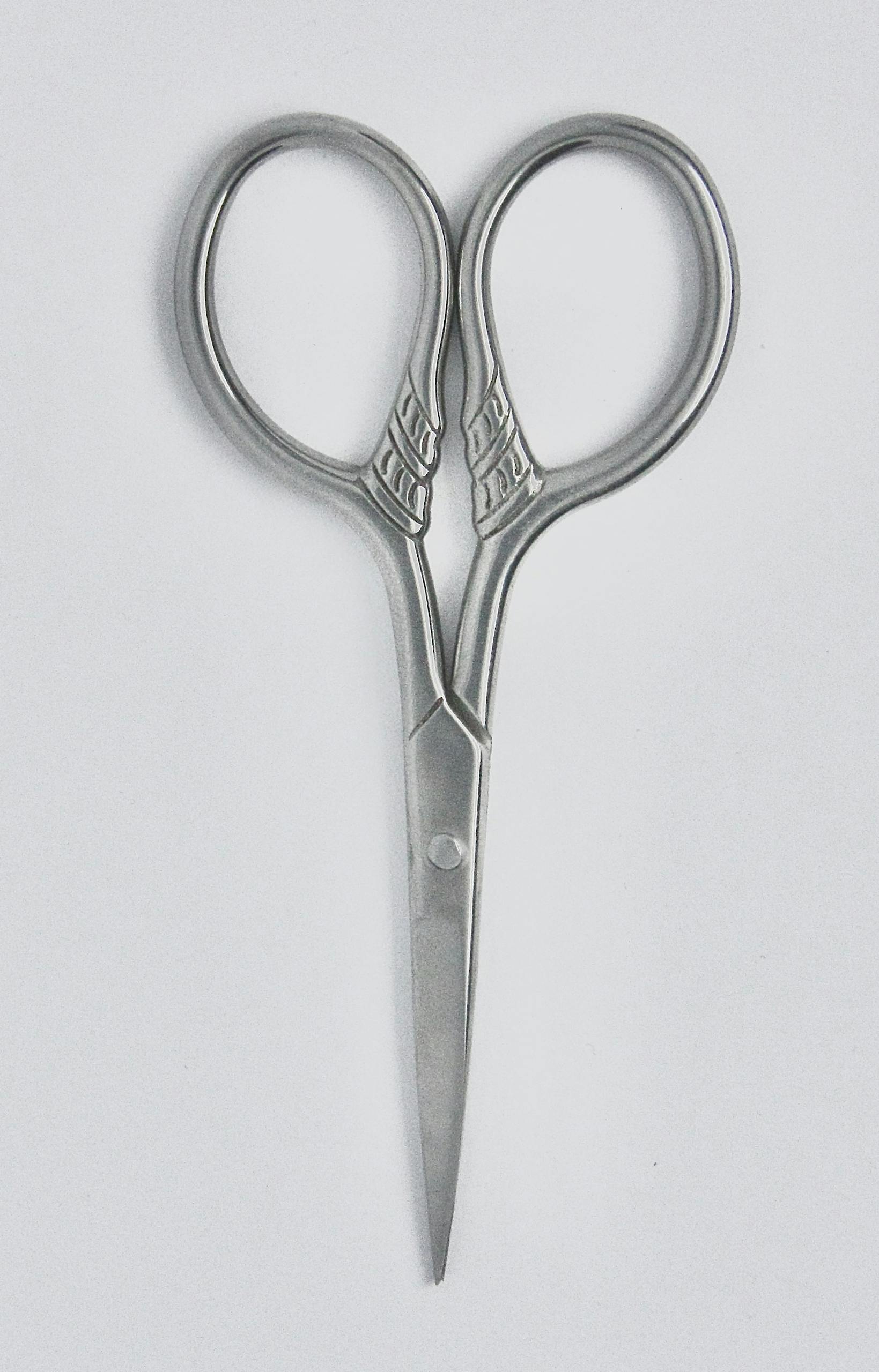 Close-up of elegant vintage stainless steel scissors on a clean white background.